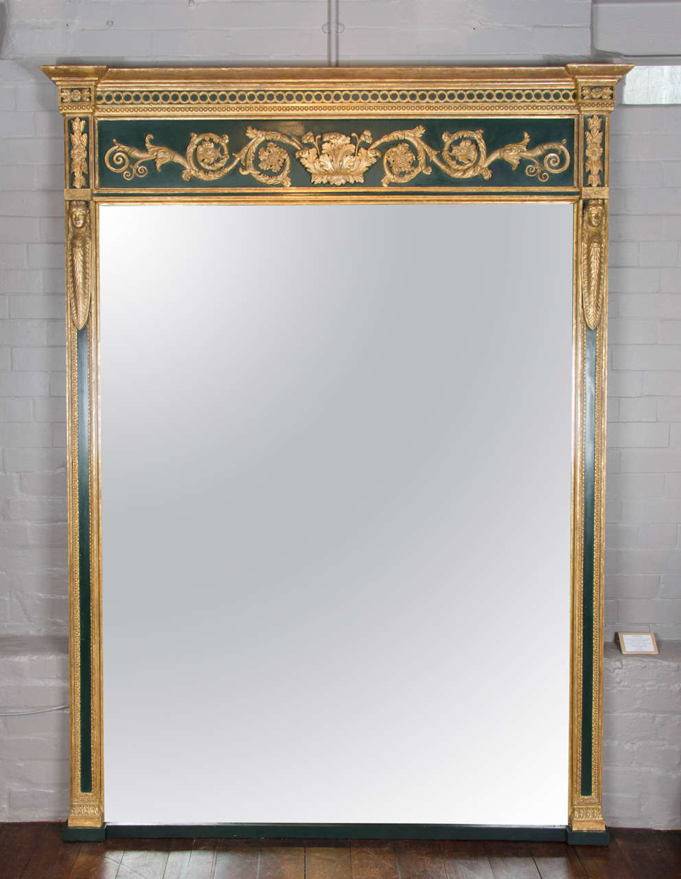 A rare early 19th century carved, painted and gilt wood mirror of large proportions retaining its original plate.
The frame with caryatids to the sides and leaf and scroll decoration atop 
to designs by George Smith.