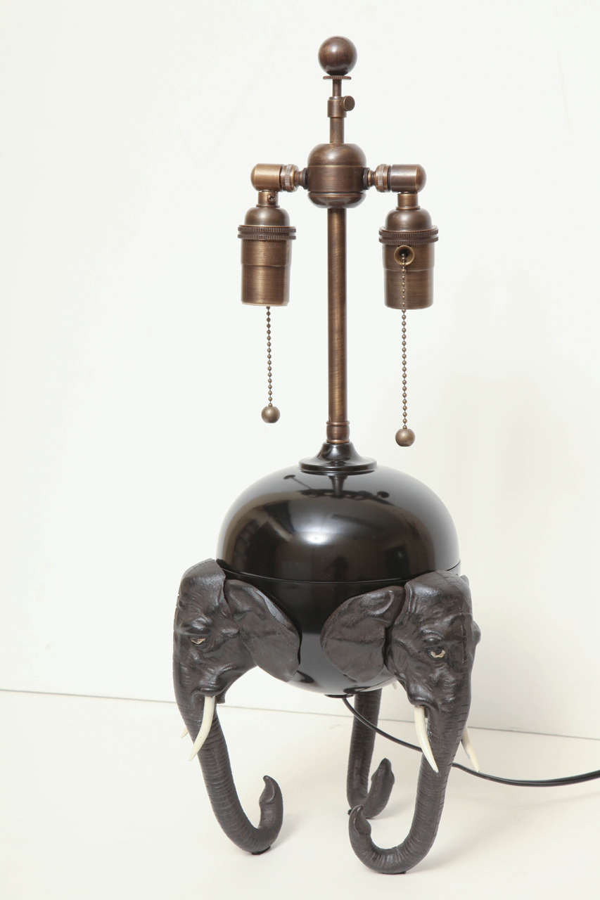 Polychromed Brass And Spelter Two Light Lamp With Three Elephant Heads With Tusk Serving As A Tripod Base.