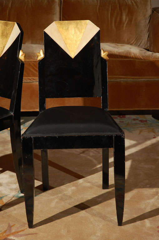 Art Deco side chairs in black lacquer. Beautiful 24-karat gold leaf and ivory lacquer detailing on the back rest on a fan pattern and gold leaf half-star details.
Chairs are upholstered in black silk.
Original condition. If you'd like them to be