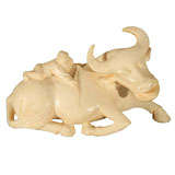 Carved Ivory ox, recumbent with rider and harness