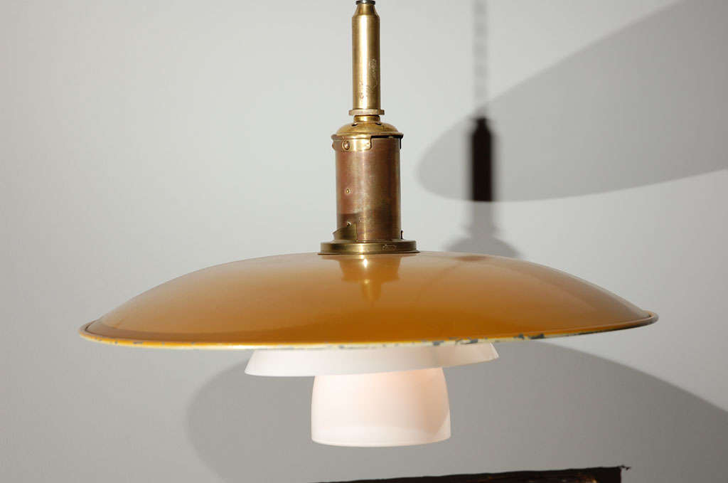 an early ceiling fixture by poul henningsen . enameled yellow top shade with bottom 2 tiers in frosted glass. stamped. original condition.