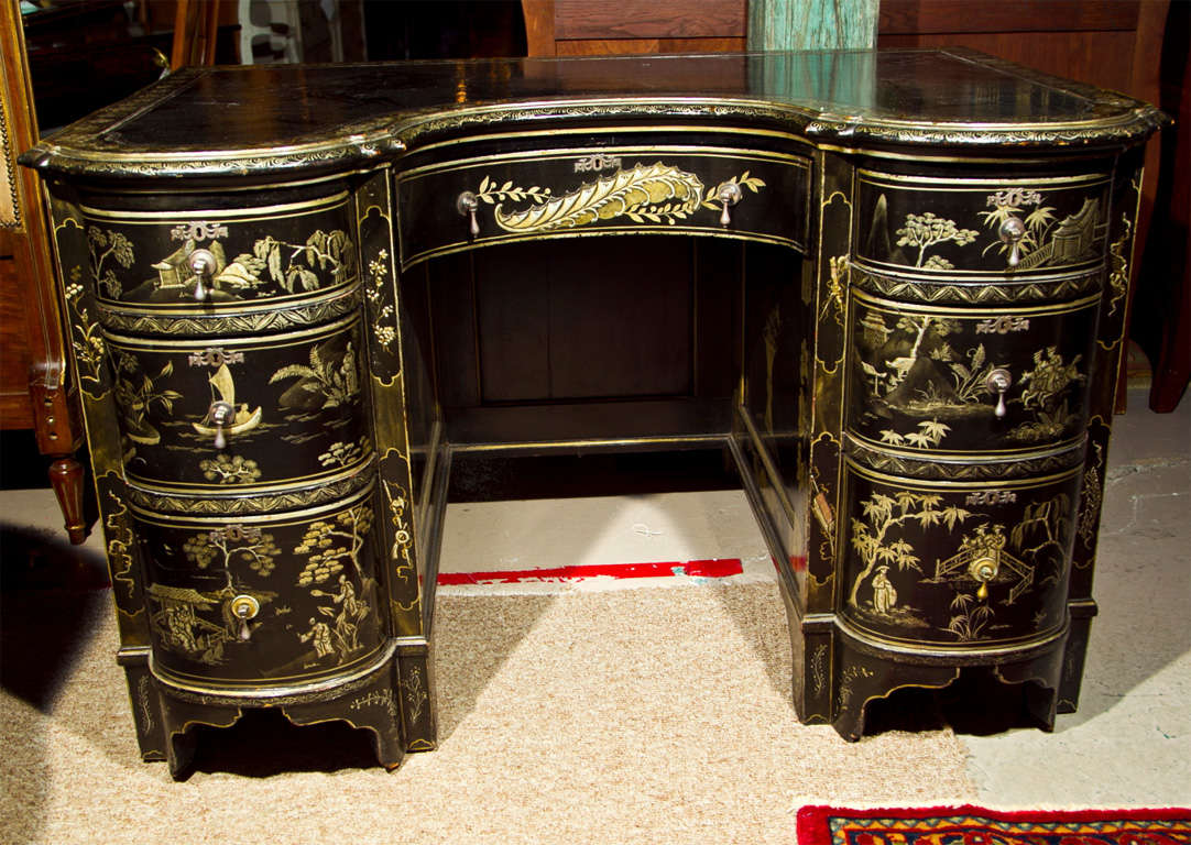 Gorgeous French Chinoiserie style vanity table, circa 1940, overall ebonized with beautiful raised painting, the concave top over a single drawer flanked by two pedestals with three pull-out drawers on each side, raised on bracket base. Truly