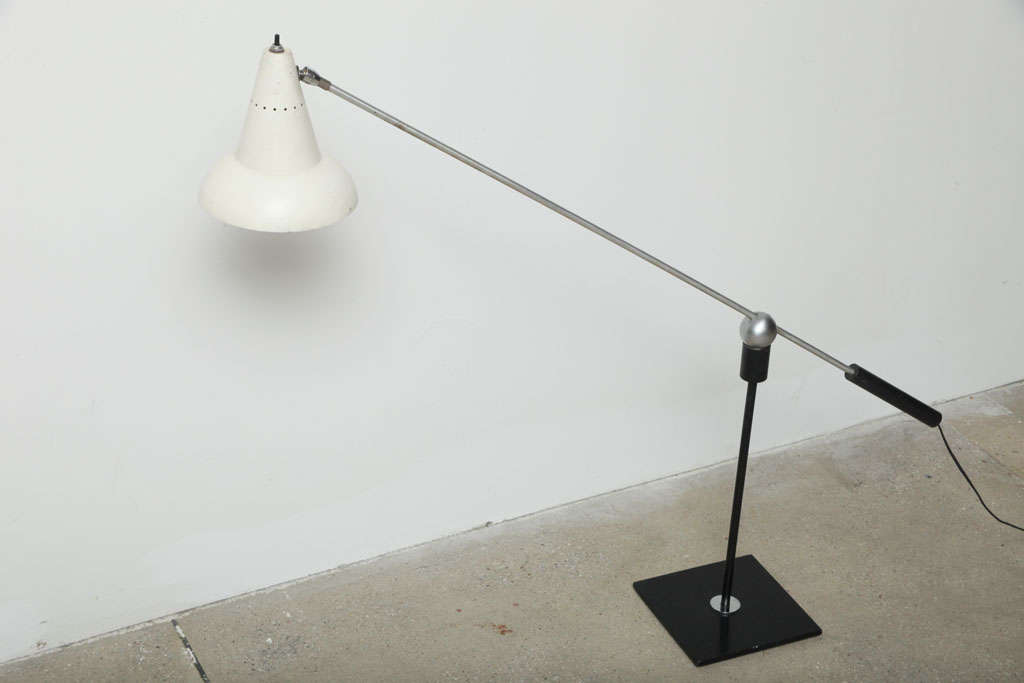 Lampe de table Gilbert Waltrous pour Heifetz Manufacturing Co. Le bras repose sur une boule magnétique de 3 pouces perchée sur une tige montée sur une base carrée émaillée noire et peut pivoter à 360 degrés.

Provenance : Cette pièce a été achetée