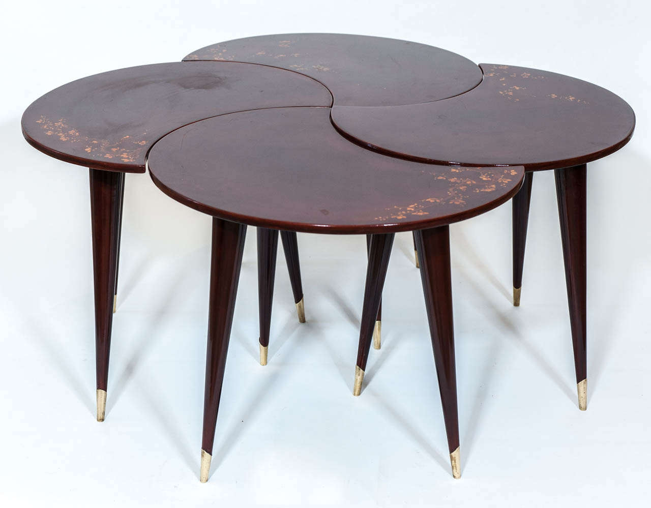 A fabulous and unique multi- tabled cocktail table with
gold floral decoration. The heavily lacquered table is a deep bergundy red
and has polished brass feet.