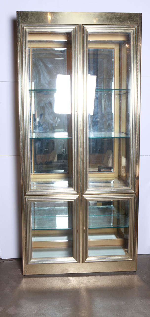 Pair of simple and elegant brass cabinets with the exquisite craftsmanship of  Mastercraft. Lighted from the top and bottom.