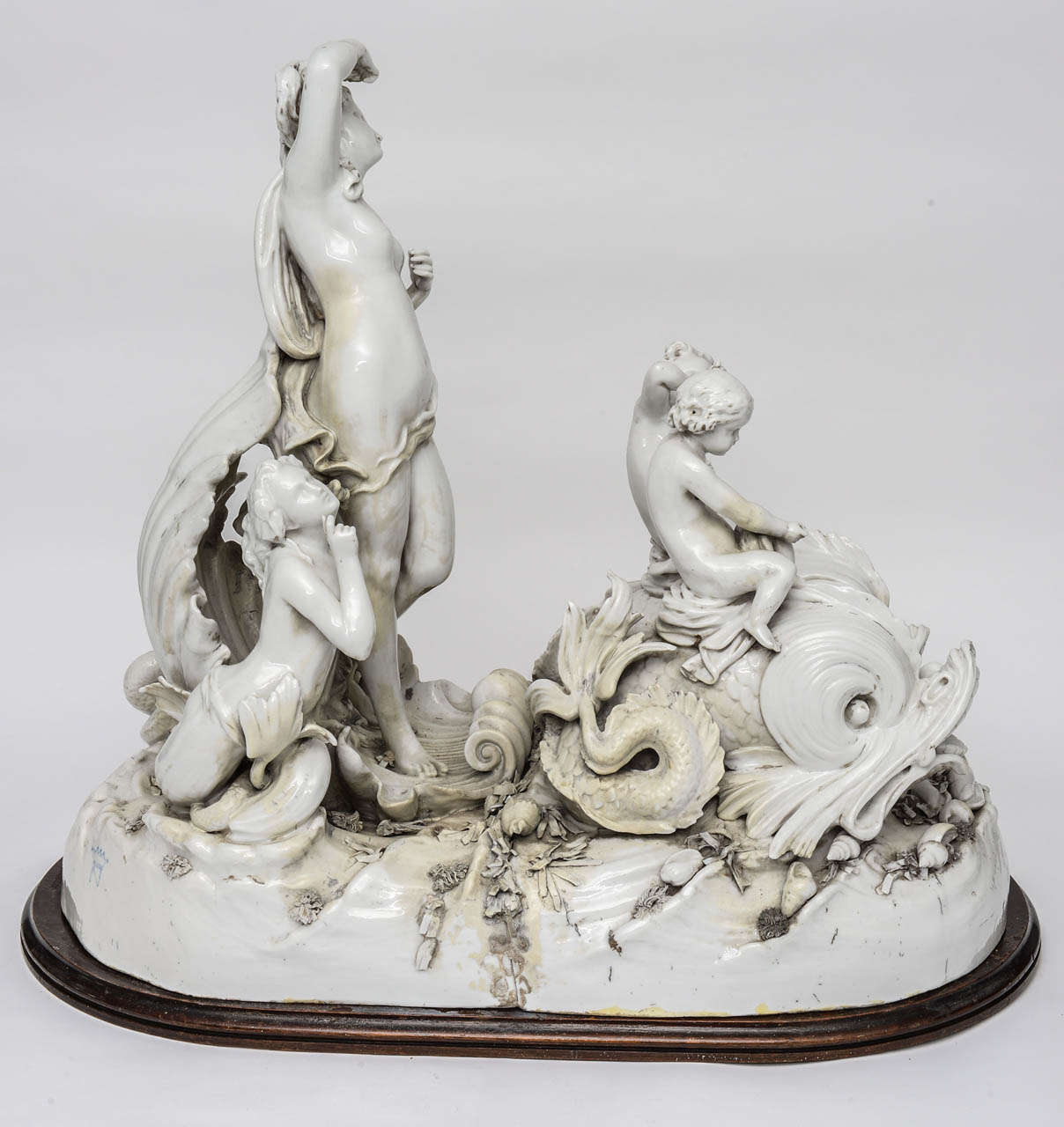 This large Capodimonte centerpiece featuring Amphitrite, goddess of the sea and wife of Poseidon, riding a seashell chariot drawn by two dolphins was part of a full table garniture but can stand alone as an impressive confection of porcelain