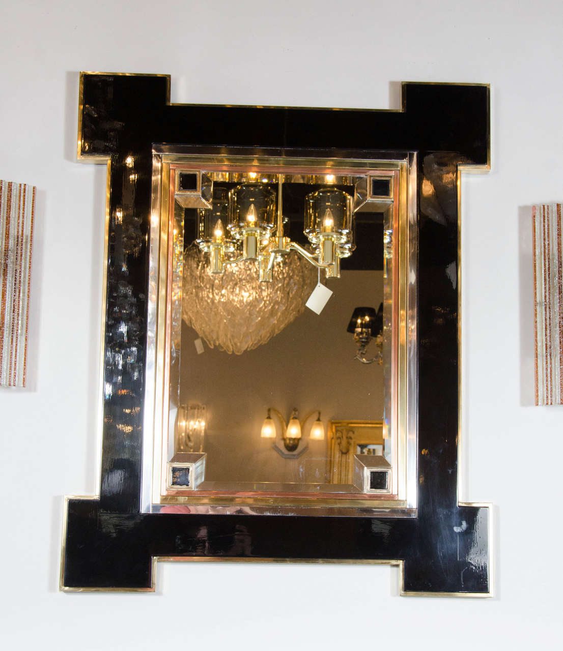 This stunning wall mirror- realized in black lacquer, chrome, copper and bronze- represents the collaboration of two legends: The fabled French actor Alain Delon and the esteemed French design house Maison Jansen. It features a skyscraper style