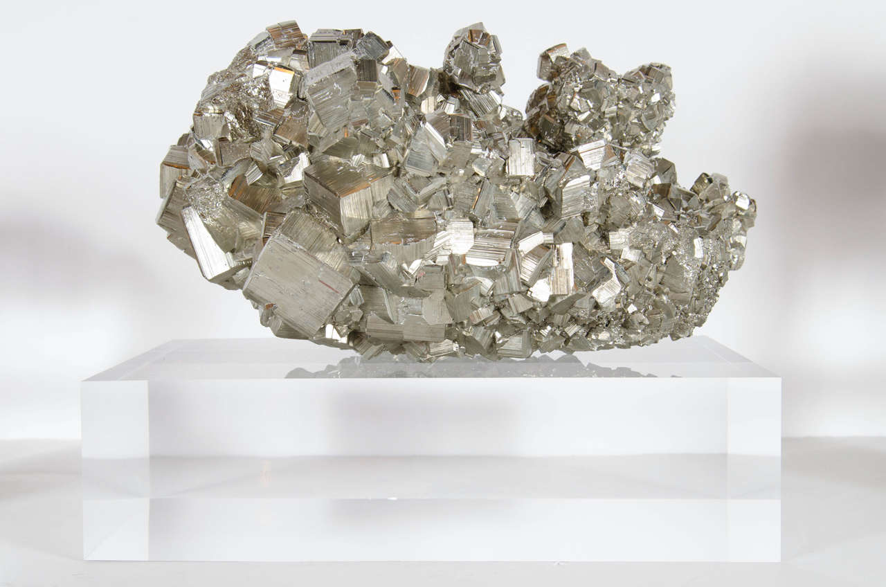 This exceptional pyrite mineral specimen is spectacular in its form.  This sizable and stunning mineral specimen of Pyrite demonstrates the aesthetic power of nature at its finest. Displayed atop a custom thick Lucite base, the Pyrites dramatically