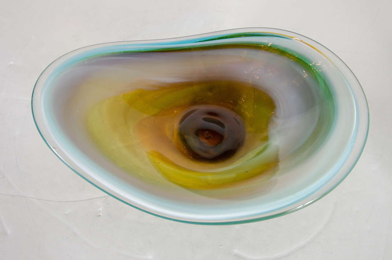 This gorgeous hand-blown Mid-Century Murano Glass bowl features an elongated ovoid raindrop design with accentuated sides that sit at a heightened level as the bowls interior section is dropped down for added design and dimension.  The bowl is shown