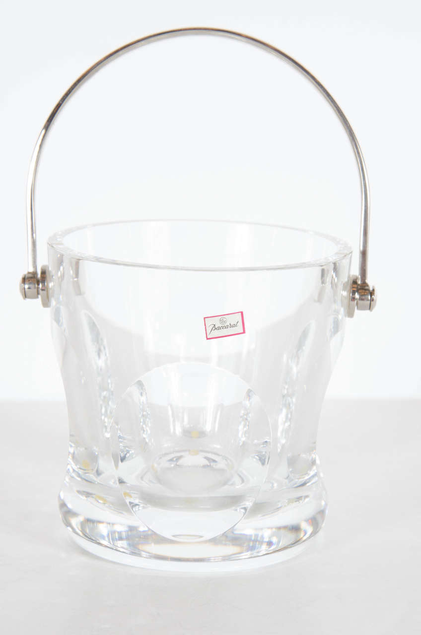 This beautiful and fine crystal ice pail will add sparkle to any bar. It features a silvered handle holding the crystal ice pail that has stylized geometric circular designs. It is also signed Baccarat as well.