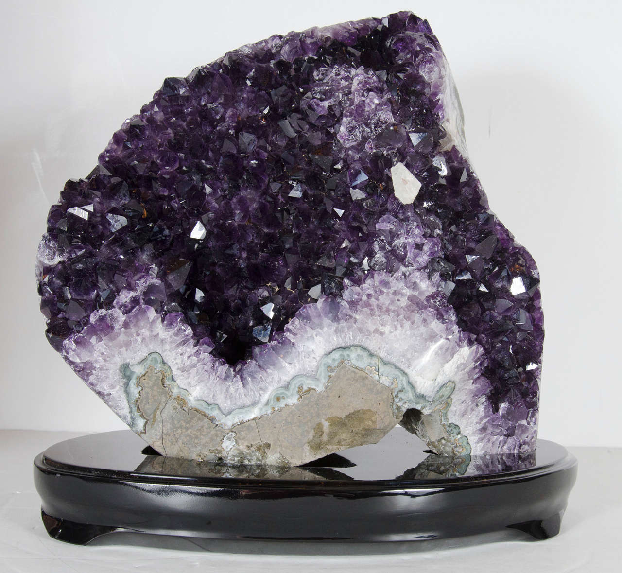 This unique rock crystal features a beautiful mixture of amethyst and clear quartz crystal. It's natural formation is intricate and is floating on a ebonized walnut base.