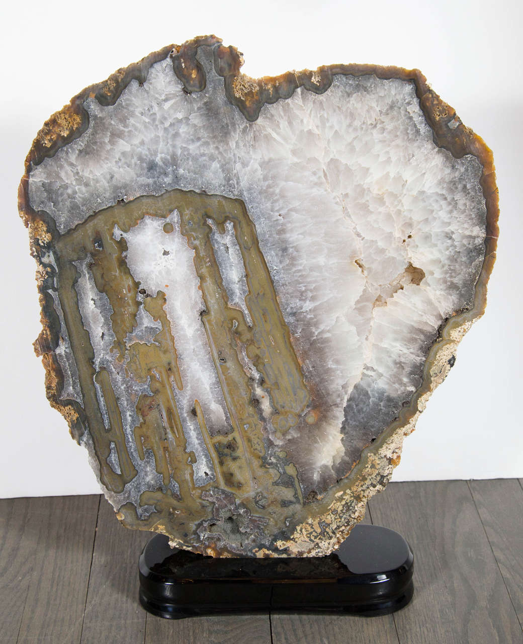 This luxurious sliced organic rock specimen is dazzling. It features gorgeous hues of tobacco,pearl & umber, and is mounted on an ebonized walnut base. It would look extremely sophisticated  in any room or decor.
