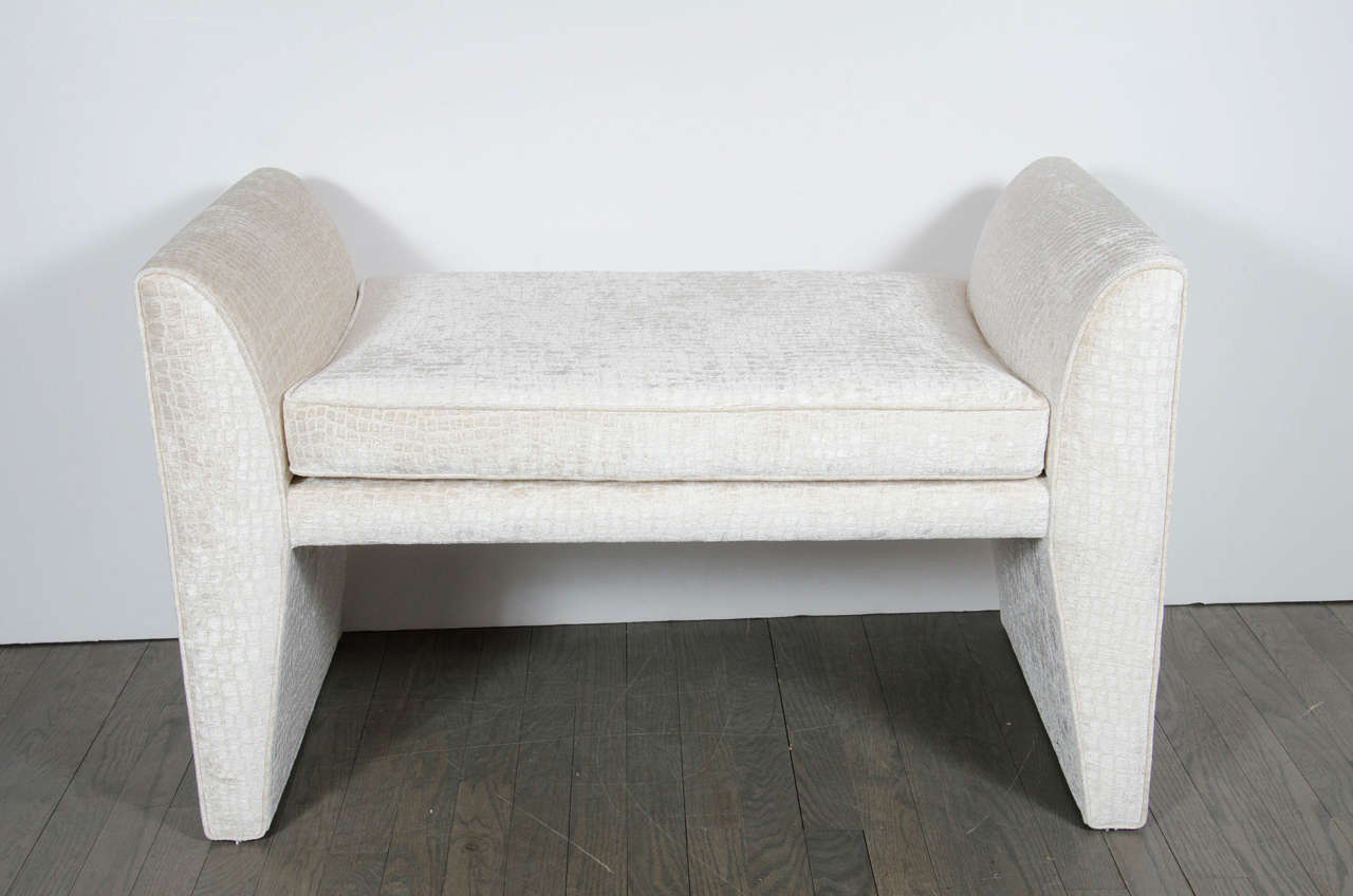 Mid-Century Modernist upholstered bench in gauffrage oyster crocodile velvet. This Mid-Century Modernist bench features an elongated bench seat that is flanked by the benches side supports that are designed with a dramatic height and an overall