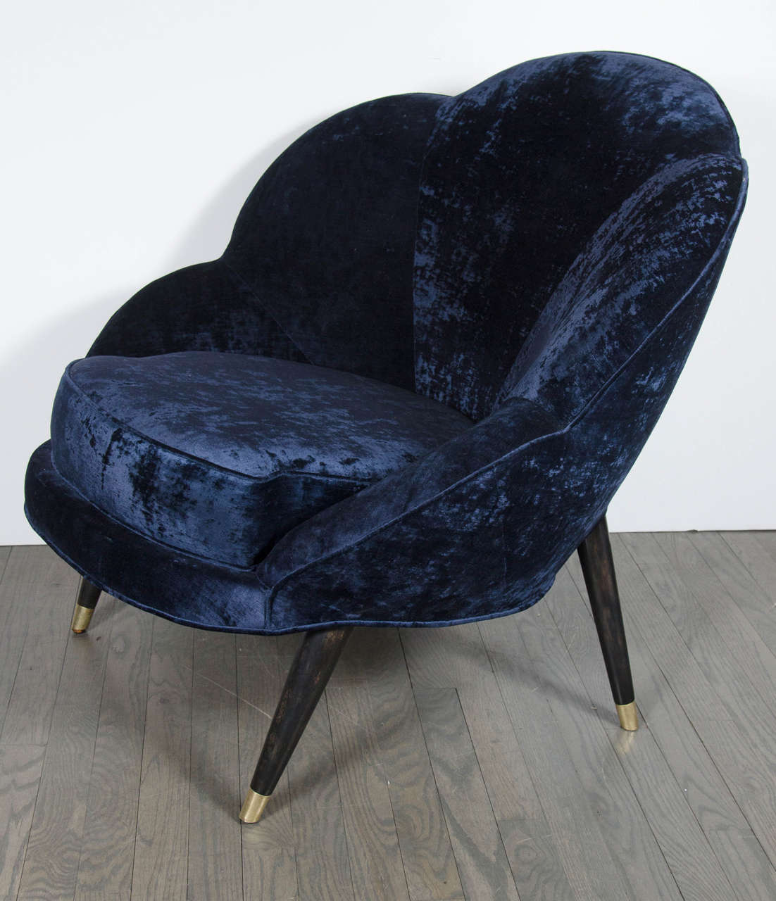 Mid-Century Modernist 'Flower' Chair with Ebonized Walnut legs, brass sabots and upholstered in a sapphire blue velvet upholstery.  This playful but sophisticated chair features a streamlined style.  The chairs curved back takes the shape of a
