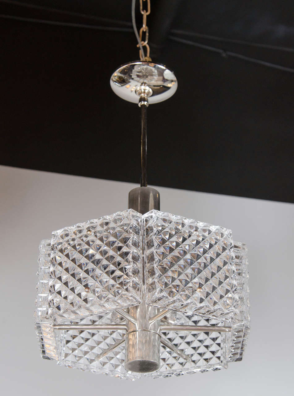 This exceptional Mid-Century Modernist chandelier by Kinkeldey is extremely sophisticated. With its octagonal shape, textured relief glass design, and chrome fittings - it is sure to make any room shine with its stature. It is sculptural in its