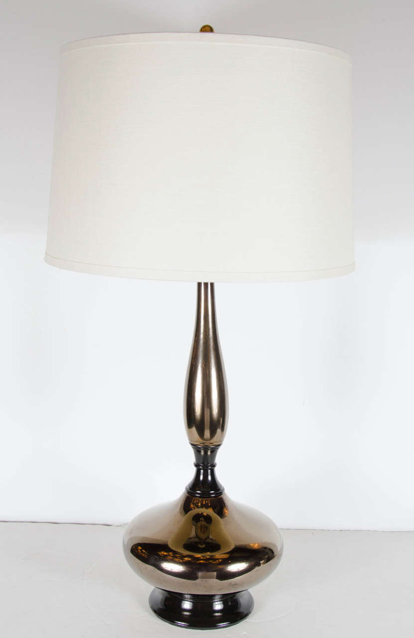 This ultra chic lamp features a bronze ceramic finish with black enamel accents. It has an elongated stylized hourglass form with black enamel bases and fittings. It has been newly rewired and fitted with a custom shade.