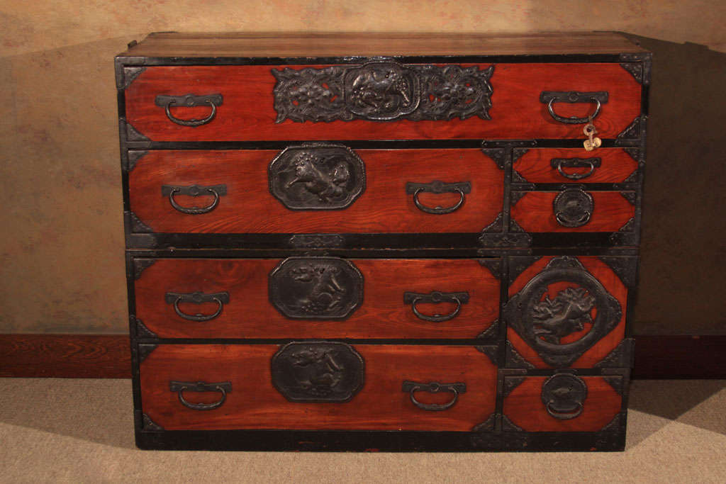 An exceptional Japanese two sectional clothing chest (isho kasane dansu) from the Sendai region, north of Tokyo. The tansu with keyaki (zelkova) wood drawer and door fronts with rich translucent red lacquer finish and sugi (cryptomeria) wood case.