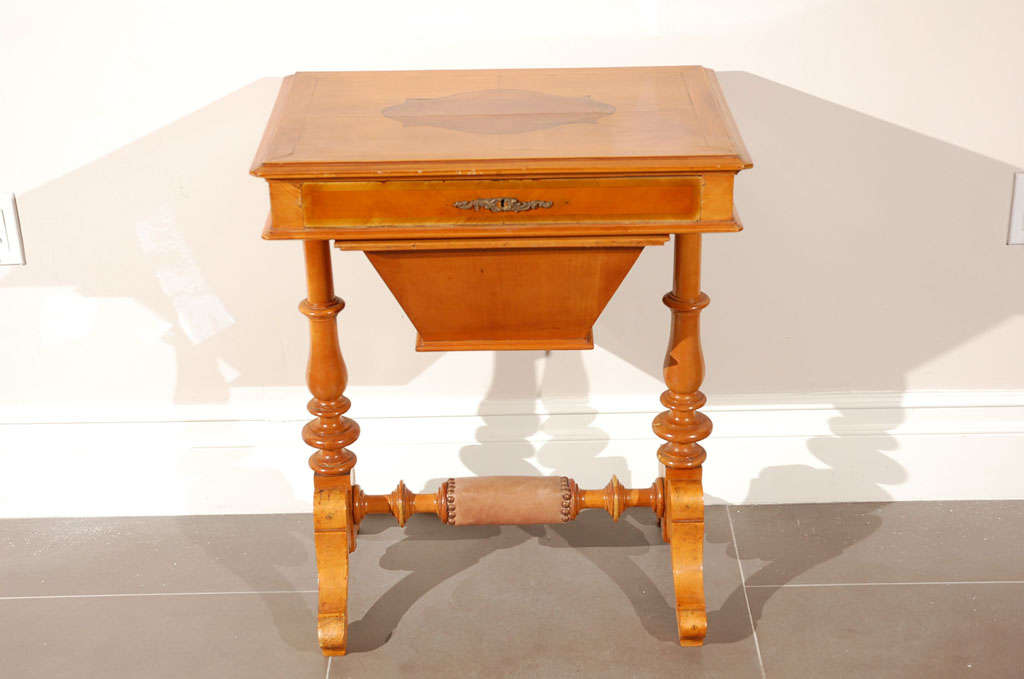 This 19th Century English sewing table with medallion inlay, has one drawer and a pull out bin.  Of course can be used as occasional table or night stand.  Has leather foot rest.  Beautifully finished in caramel color.