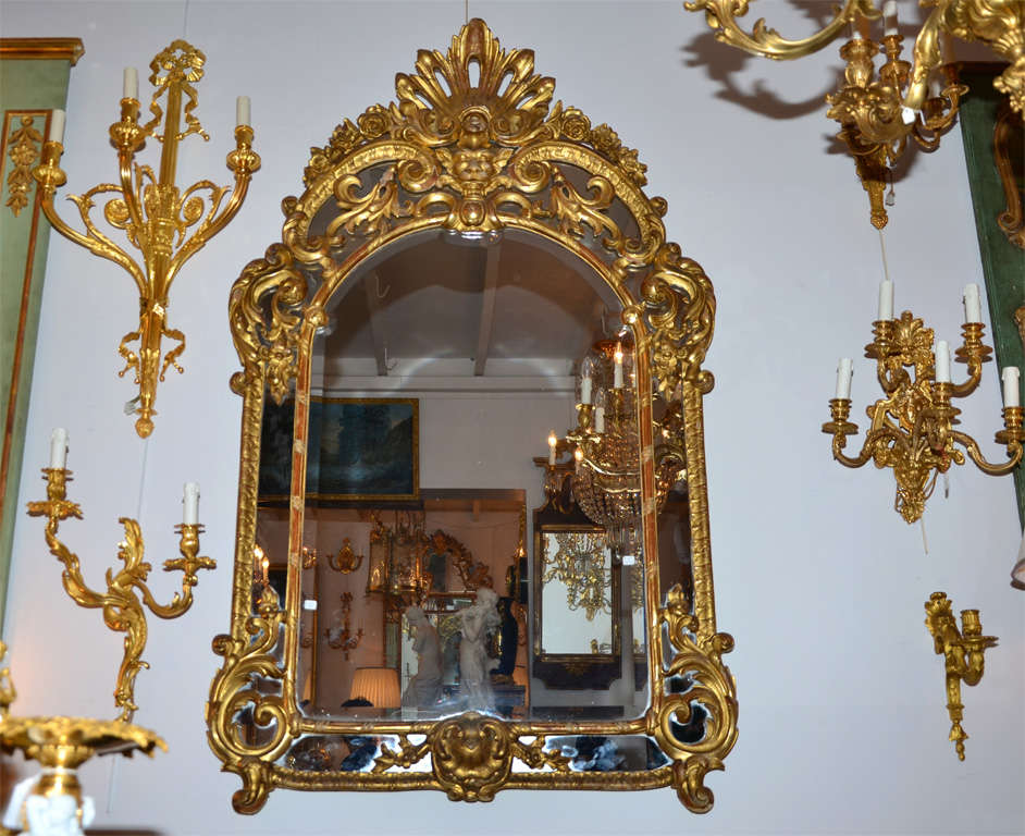 French Very inusual gilded and carved wood mirror, Régence Style. For Sale
