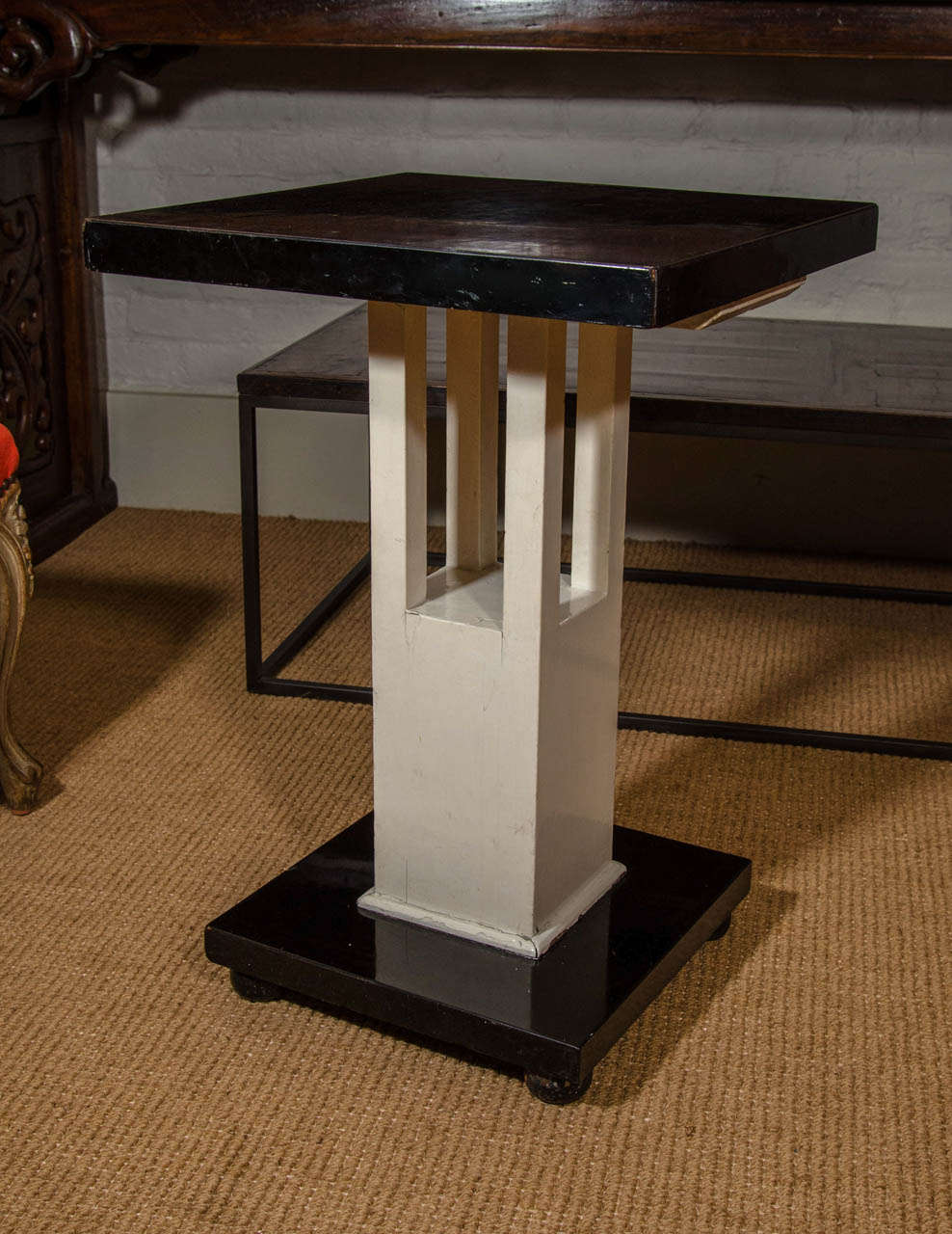 With rectangular black formica top on a white painted pedestal, on a black formica square base with round feet