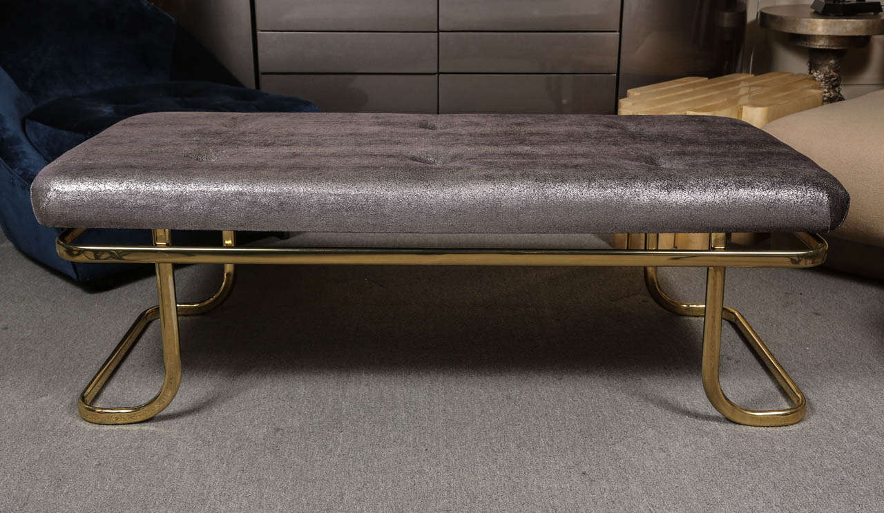 Graceful brass bench with glamorous metallic upholstery fabric from Romo fabrics.