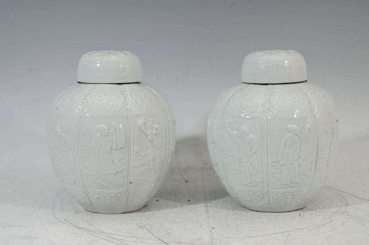 A fine pair of Blanc de Chine porcelain octagonal ginger jars with matching covers.  The sides with sharply molded and have incised designs of each of the eight Taoist Immortals of good luck, prosperity and health (Ba Xsian). The covers are molded