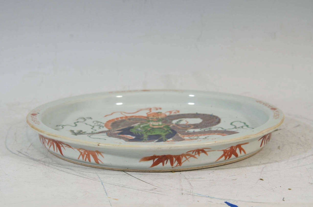 A rare and powerful Chinese porcelain exhibition tray realistically painted with a four-claw dragon in famille-verte enamel colors; the base left unglazed

Good condition with age appropriate wear.

Diameter (approximate): 14 1/2 inches (37 cm)