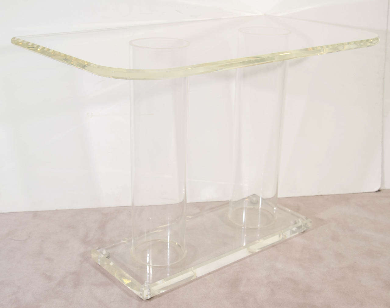 A vintage pair of console tables with wide tubular column supports and pedestal base. Console top has rounded front corners.

Good vintage condition with age appropriate wear.