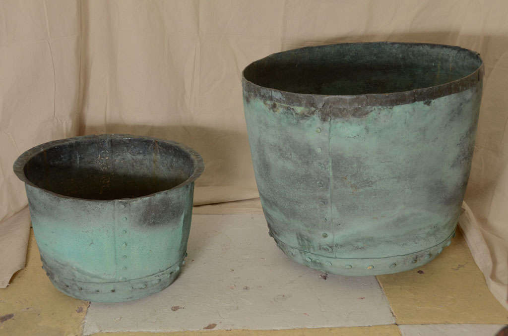 KNOWN AS COPPERS--WERE PLACED IN A BRICK SURROUND WITH FIRE UNDERNEATH TO BOIL WATER WHERE CLOTHES WOULD BE LAUNDERED IN. COPPER ON RIGHT VERY LG. SIZE--BOTH WITH BEAUTIFUL VERDIG PATINA
MAKES GREAT PLANTER OR LOG BARREL-- CAN BE SOLD