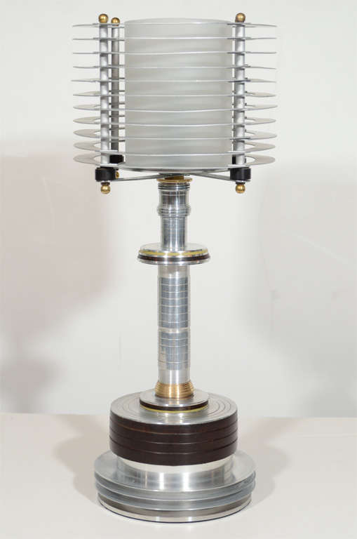 This rare lamp exemplifies the Art Deco Machine age era in America. This lamp is brushed aluminum , glass (which is original) and bakelite. Newly rewired.