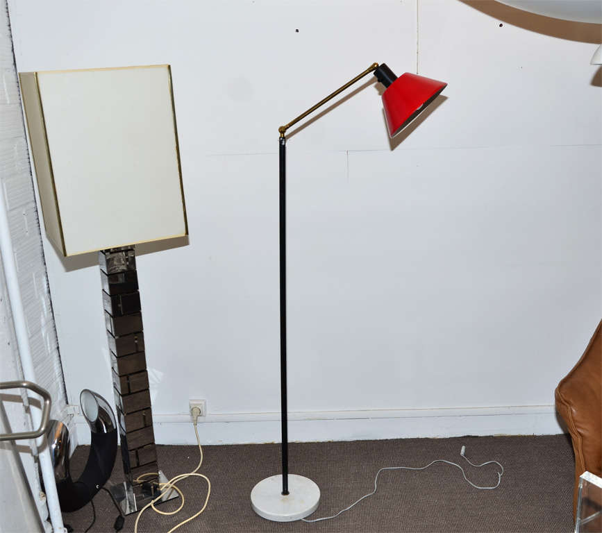 1950s Italian floor lamp by Stilnovo, with white marble base, shaft in black metal, articulated arm in gilded metal; red metal shade. Re-wired for electricity for European use.