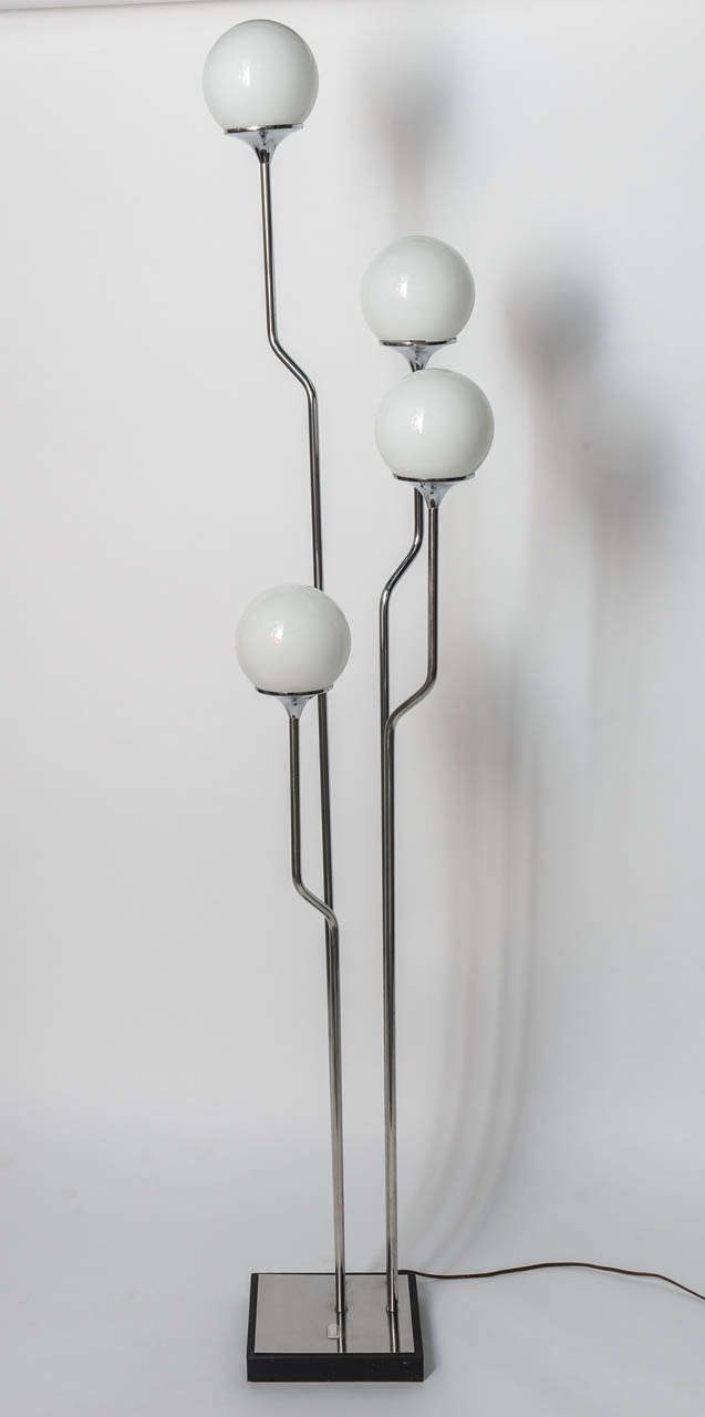 This mid-century chrome floor lamp will add light and height to a room in a most unique way.  Four chrome stems hold frosted glass orbs at different heights.  The bent lines are reminiscent of a subway map.  This simple beauty will blend in with