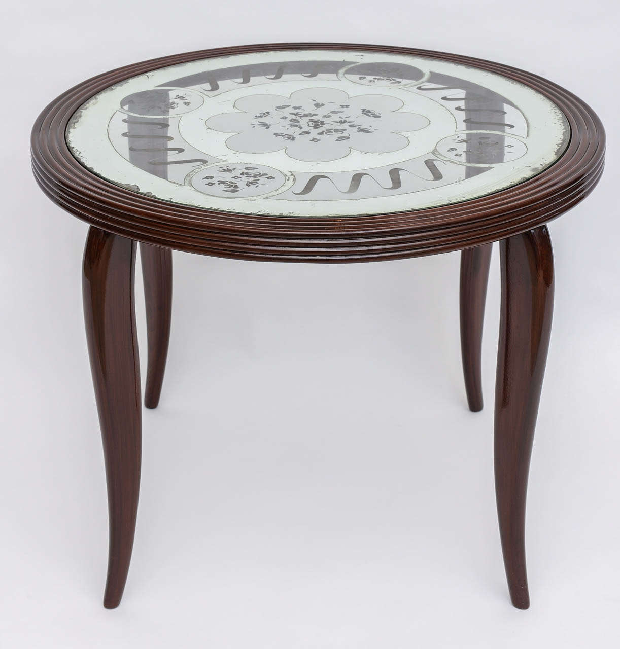 The round table top with etched and mirrored glass insert supported by foru tapered legs.