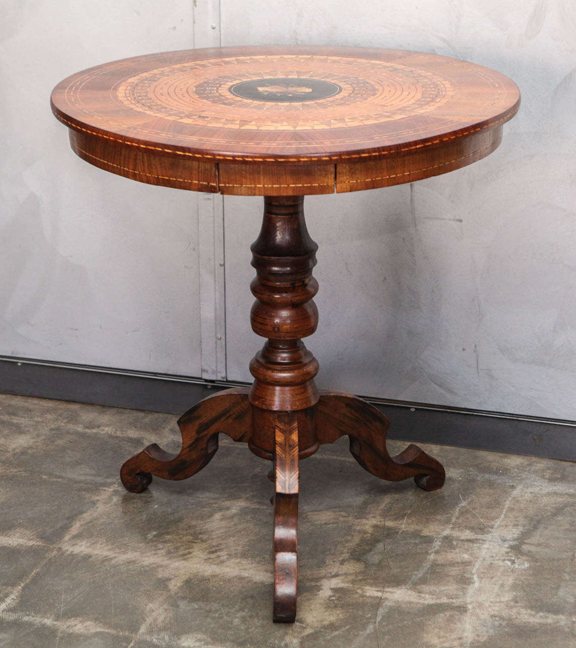 This table an exquisite example of parquetry and marquetry artistry. The combination of figurative and geometric woodworking techniques add to the preciousness of this handcrafted late 1800's piece. There is a little drawer that measures 6.25"