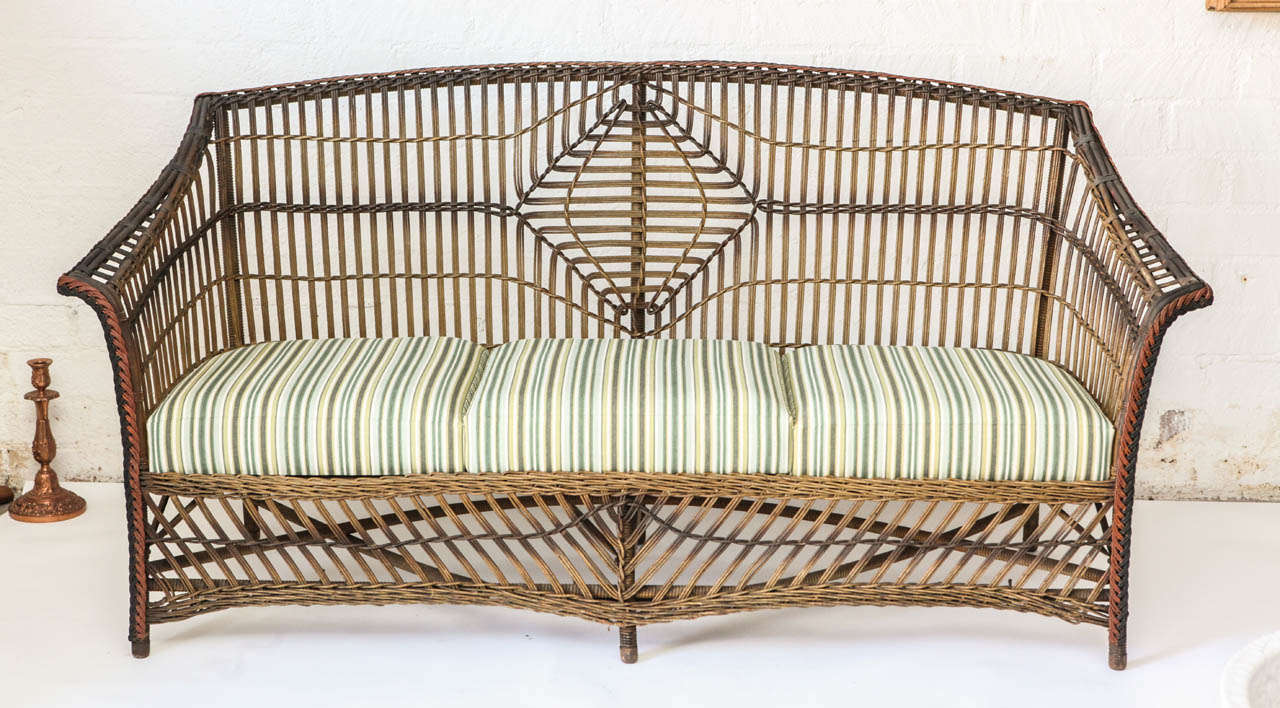 This Settee is an rare example of Loyd Loom Wicker Furniture produced in the united states. Loyd Loom furniture was the invention of American, Marshall B. Loyd who developed various methods to create wicker furniture from twisted paper. His