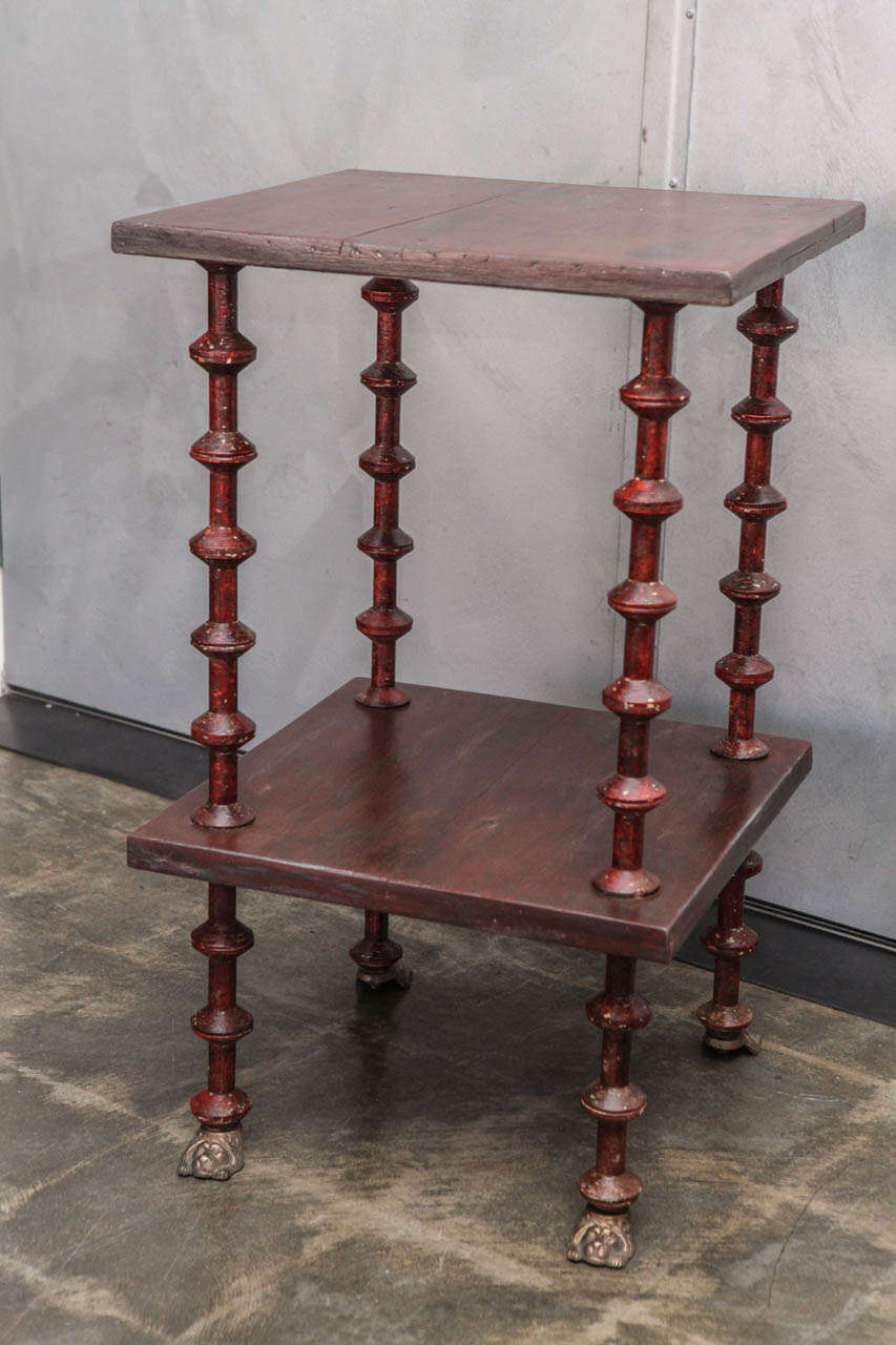 This handsome two tiered spool side table is made of pine with a lustrous red stain and four charming brass lion head feet. The legs are made with 36, 3" thread spools on strengthening center rods. This table is worth a closer look with it's