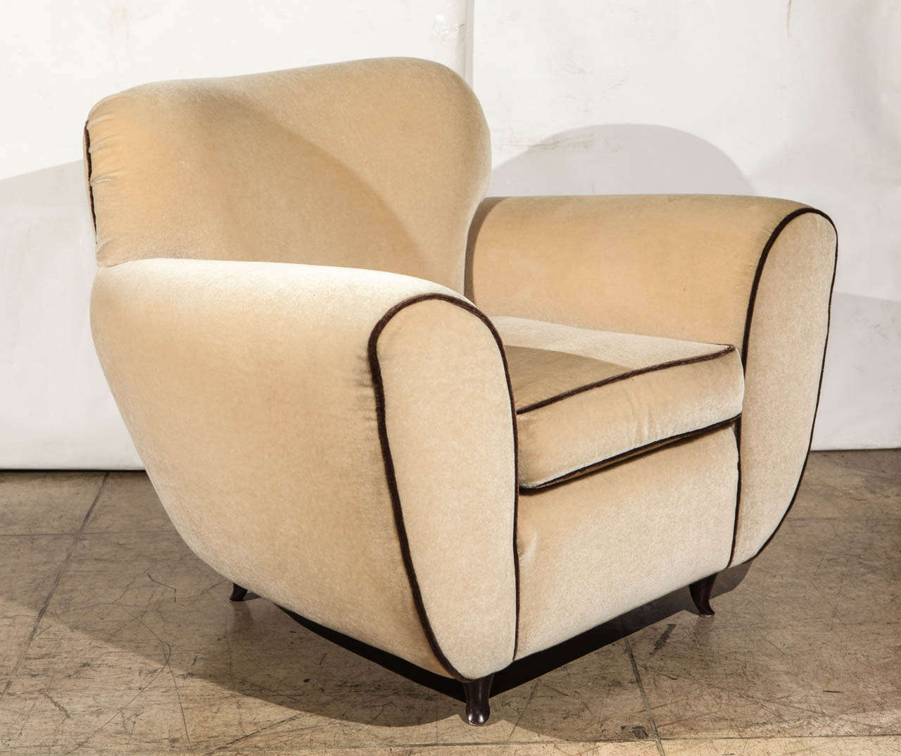 An elegant and very comfortable pair of Art Deco armchairs by Paolo Buffa. Upholstered in a light beige mohair with dark brown mohair piping. Accented with graceful original curved wood legs.