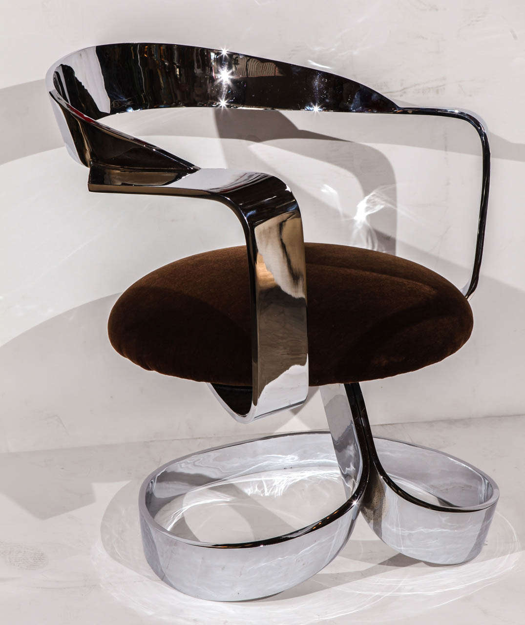 An amazing polished chrome plated steel ribbon chair. Chair seat is upholstered in a dark brown mohair and swivels.