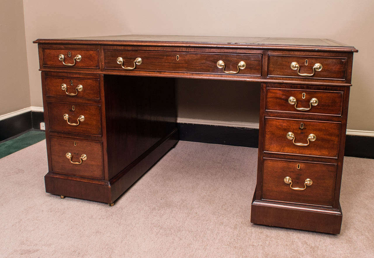 This true partners desk has 18 working drawers (nine on each side) with key. Excellent patina with rich mellow tone to the wood and leather top. Beautiful hand-wrought bale hardware. Very good proportions, comes into three parts for ease of moving.