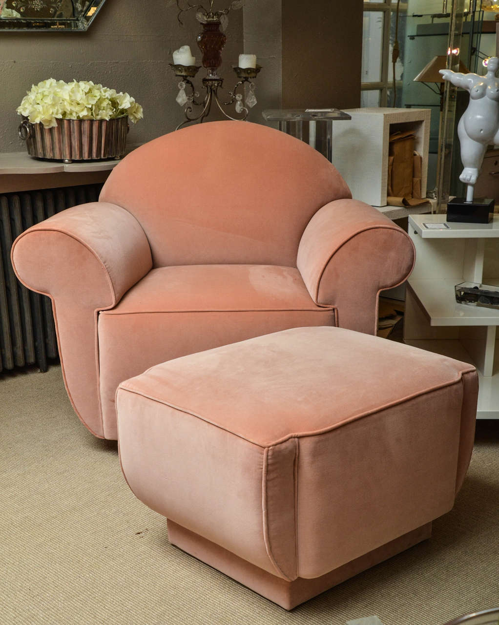 Striking Deco style club chair and ottoman upholstered in apricot velveteen.
Dimensions: The ottoman is 26 W x 21 D x 18 H.