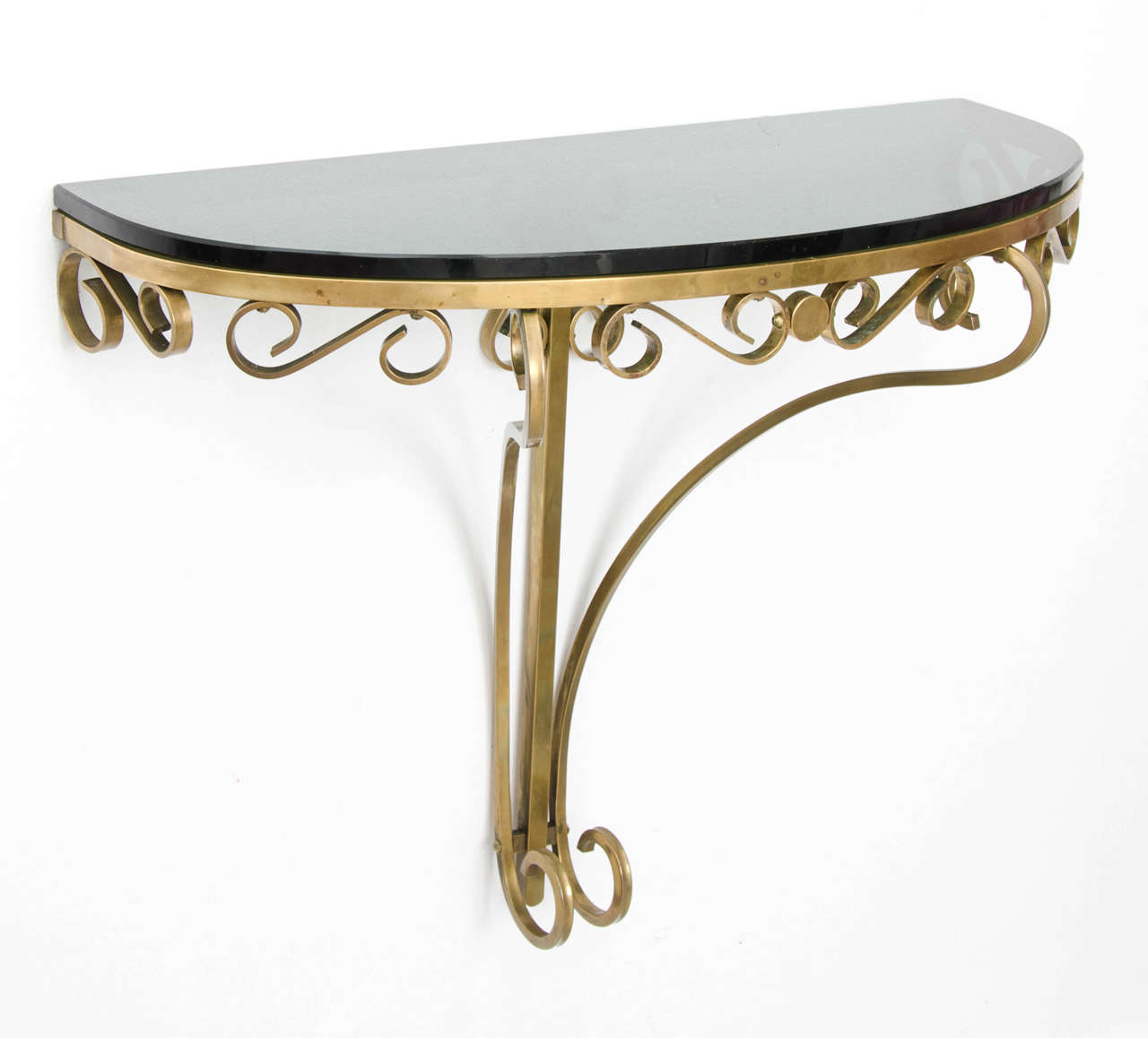 Wall-mounted brass console table with original green glass top.  Nicely engineered piece with each scroll screwed into the frame.  Glass simply sits on top of the brass frame.  Probably Italian, 1950s, designer unknown.

The mirror shown in the