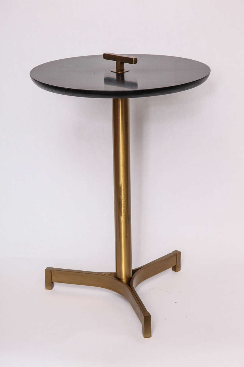 A 1950s modernist architectural brass and bakelite side table.