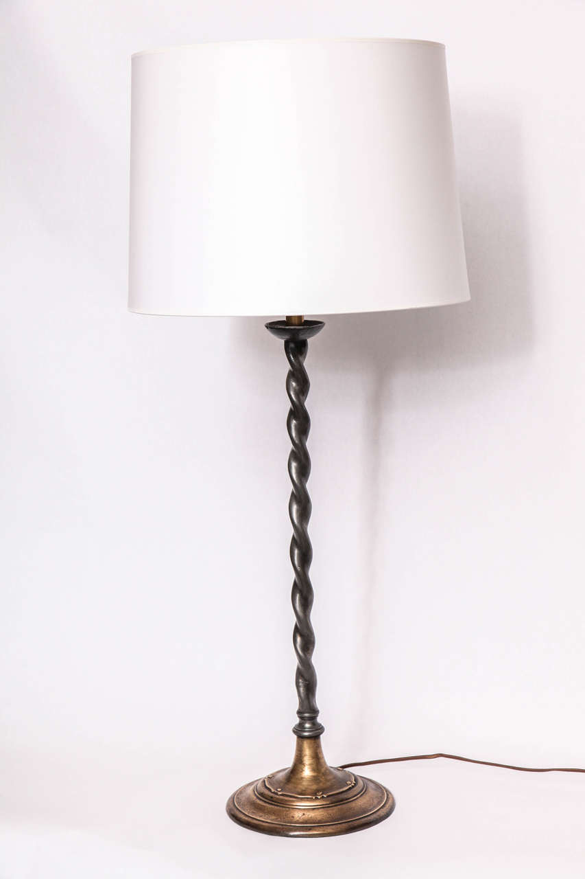 A 1920s patinated iron and bronze table lamp signed Oscar B Bach studios NY.