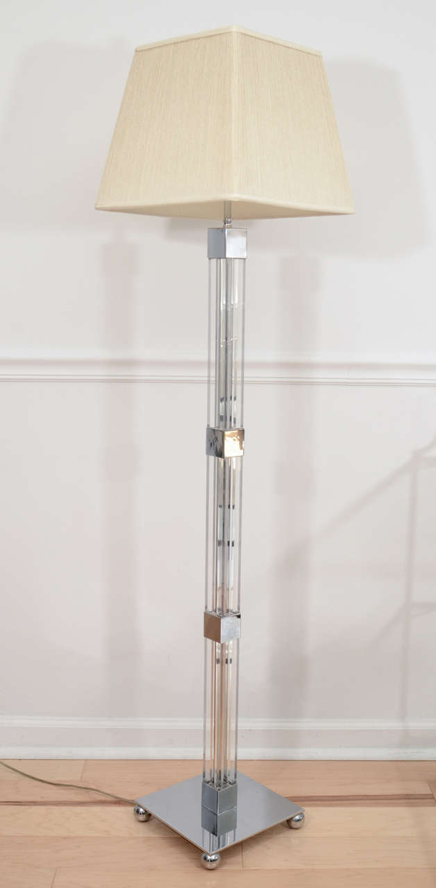 Elegant vintage floor lamp finely executed in lucite and chromed steel. Double socket with original silk string lampshade.