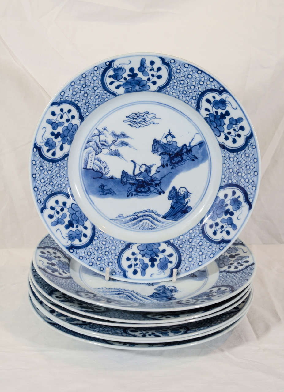 A pair of Qianlong (mid-18th century) Chinese Blue and White dishes with a hunting scene showing noble riders in a Chinese landscape. They race through hills at full gallop with bows drawn. This is the well known 