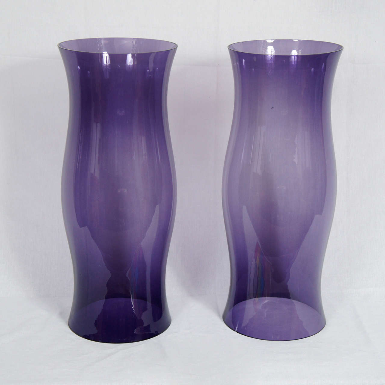 This large and impressive pair of Hurricanes are hand blown and show the nature and character of that hand made work. Notice the subtle color changes that have occurred within the mixing and blowing process. The glass has been mixed with manganese