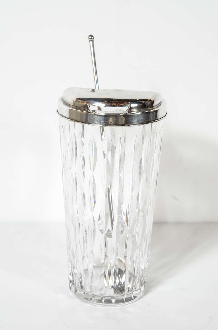 This glamorous Mid-Century cut crystal pitcher by Tiffany & Co. features  a sterling silver lid and stirrer. Both the pitcher and stirrer are signed Tiffany & Co.