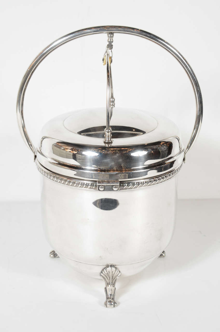 This unique Art Deco silver plate champagne bucket features a built in alternating flip-top lid which exposes an ice bucket when opened in one direction and bar accessories when opened in the opposite direction. In addition to it's innovative