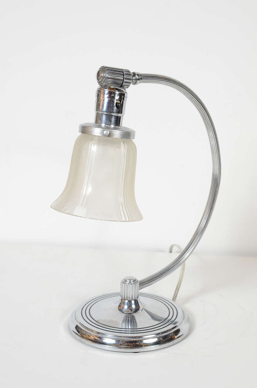 This gorgeous Art Deco Machine Age table lamp has an adjustable frosted glass shade on a chrome arc base with concentric incised Deco detailing . Newly rewired.