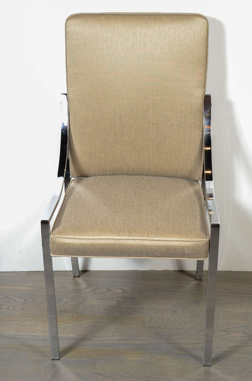 This pair of Modernist streamlined chrome dining chairs newly upholstered in metallic bronze sharkskin fabric. The design has fine, tubular chrome arms and legs with an upholstered seat and back.